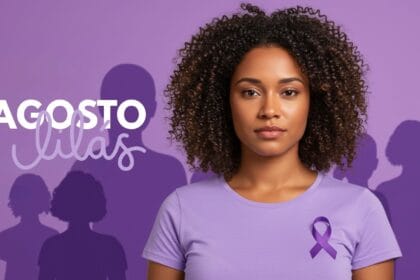 Uma mulher brasileira de pele morena clara, expressão firme e serena, usando camiseta lilás em um fundo com tons suaves da mesma cor. Ao fundo, silhuetas simbólicas de outras mulheres unidas, representando sororidade. O cenário transmite esperança e força. Elementos visuais sutis indicam proteção, como luz suave em torno da personagem principal. O estilo é realista e levemente editorial, próprio para capa de artigo informativo sobre violência contra a mulher no contexto do Agosto Lilás.